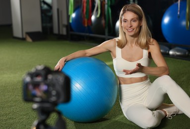 Photo of Fitness trainer recording online classes in gym