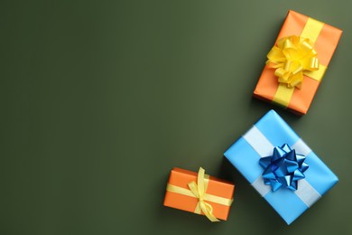 Colorful gift boxes on dark green background, flat lay. Space for text