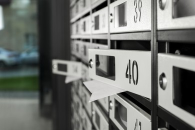 Open mailboxes with keyholes, numbers and receipts in post office, closeup