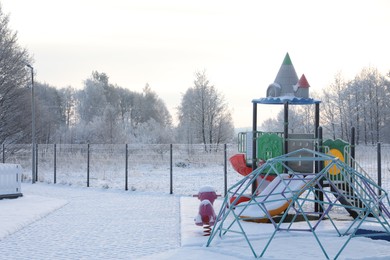 Beautiful playground covered with snow in winter morning