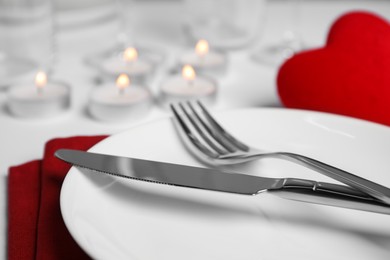 Photo of Beautiful table setting with burning candles on white table, closeup. Romantic dinner