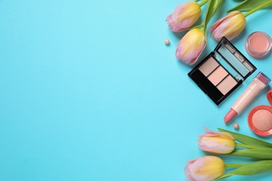 Photo of Flat lay composition with different makeup products and beautiful tulips on light blue background. Space for text