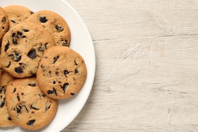 Photo of Delicious chocolate chip cookies on white wooden table, top view. Space for text
