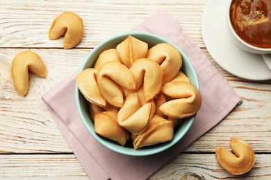 Tasty fortune cookies with predictions on white wooden table, flat lay