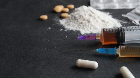 Photo of Different hard drugs on black background, closeup. Space for text