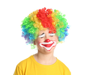 Preteen boy with clown makeup and wig on white background. April fool's day