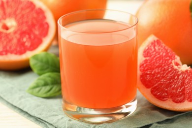 Glass of delicious grapefruit juice on table, closeup