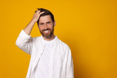 Photo of Portrait of happy bearded man on orange background. Space for text