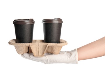 Woman holding cardboard holder with takeaway paper coffee cups on white background, closeup