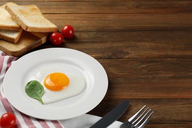 Romantic breakfast with heart shaped fried egg served on wooden table, space for text