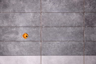Photo of Wall with grey modern tiles and hole prepared for electrical outlets