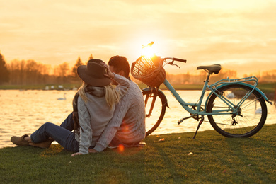 Young couple near lake at sunset. Perfect place for picnic