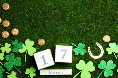Flat lay composition with horseshoe and block calendar on grass, space for text. St. Patrick's Day celebration