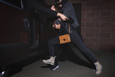 Criminals kidnapping young woman at night. Self defense concept
