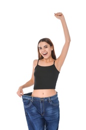 Slim woman in oversized jeans on white background. Weight loss