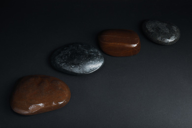 Photo of Stones in water on dark background. Zen lifestyle