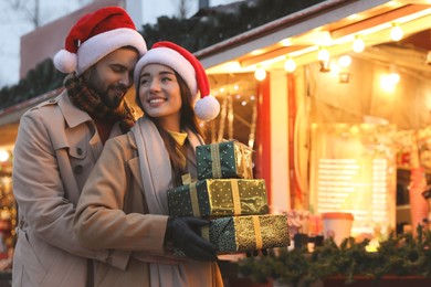 Lovely couple with Christmas presents at winter fair
