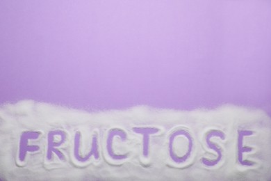 Photo of Word Fructose made of sugar on violet background, top view. Space for text
