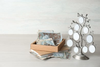 Family tree photo frame, pictures and notebook on light wooden table. Mockup for design