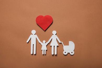 Paper family figures and red heart on brown background, flat lay. Insurance concept