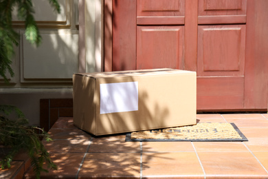 Delivered parcel on door mat near entrance