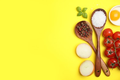 Flat lay composition with cooking utensils and fresh ingredients on yellow background. Space for text