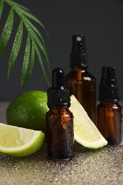 Bottles of organic cosmetic products and sliced lime on wet surface