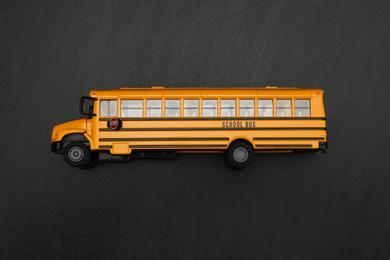 Yellow school bus on black background, top view. Transport for students