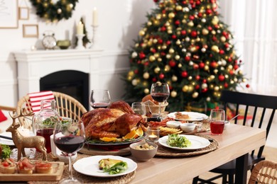 Festive dinner with delicious food and wine on table indoors. Christmas celebration