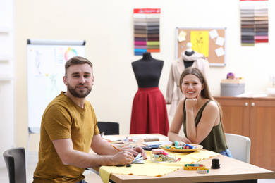 Fashion designers creating new clothes in studio