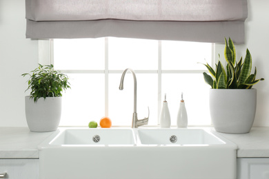 Ceramic sink and modern tap in stylish kitchen interior