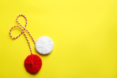 Traditional martisor on yellow background, top view with space for text. Beginning of spring celebration