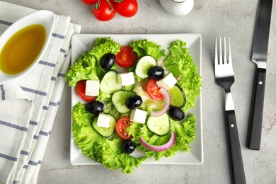 Tasty fresh Greek salad on grey table, flat lay