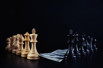 Photo of Different chess pieces and money against dark background. Business competition concept