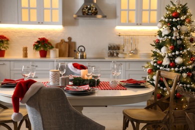 Table with dishware in beautiful kitchen interior decorated for Christmas