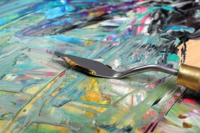 Abstract colorful acrylic paint and spatula, closeup view