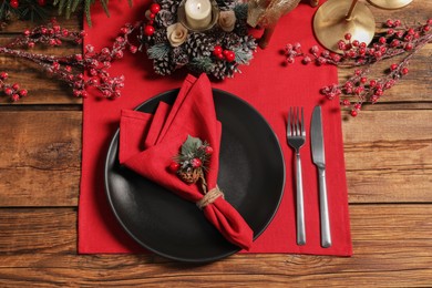 Photo of Festive place setting with beautiful dishware, cutlery and decor for Christmas dinner on wooden table, flat lay
