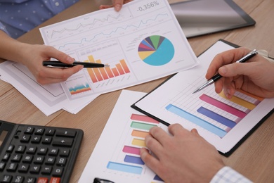Business people working with charts and graphs at table in office, closeup. Investment analysis