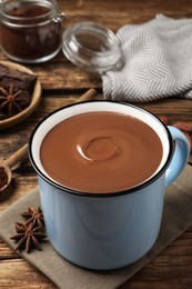Yummy hot chocolate in mug on wooden table