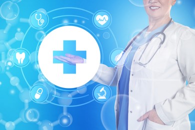 Medical technology concept. Mature doctor and illustration of cross with different icons on turquoise background