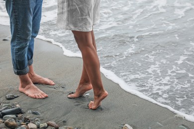 Young couple on beach near sea, closeup. Space for text