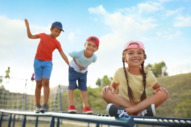 Cute children on playground climber outdoors. Summer camp