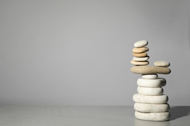 Stack of stones on grey background, space for text. Harmony and balance concept