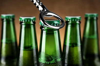 Photo of Opening bottle of beer on brown background, closeup
