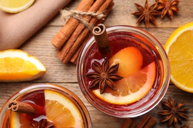 Aromatic punch drink and ingredients on wooden table, flat lay