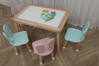 Small table and chairs with bunny ears in children's room