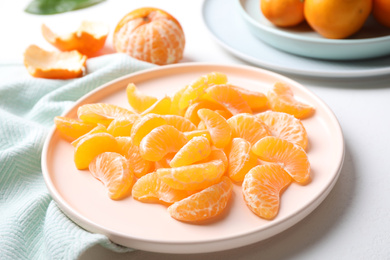 Segments of fresh ripe tangerines on white table