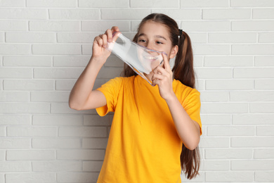 Preteen girl with slime near white brick wall