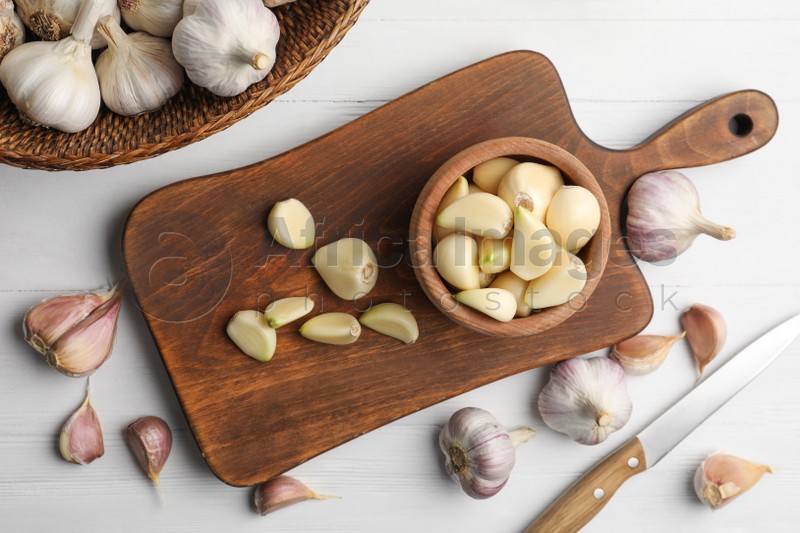 Fresh organic garlic on white wooden table, flat lay