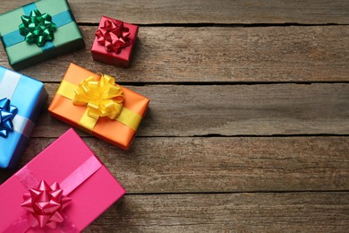 Many colorful gift boxes on wooden table, flat lay. Space for text